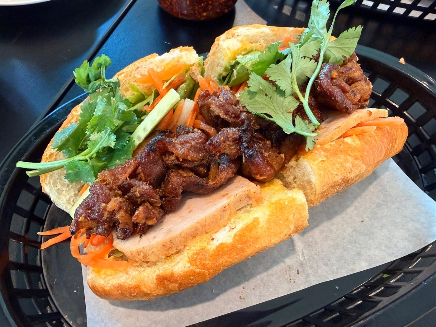 Banh mi with crisp bread, grilled meat and fresh herbs